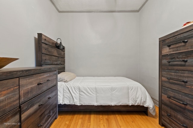 bedroom featuring light hardwood / wood-style flooring and ornamental molding