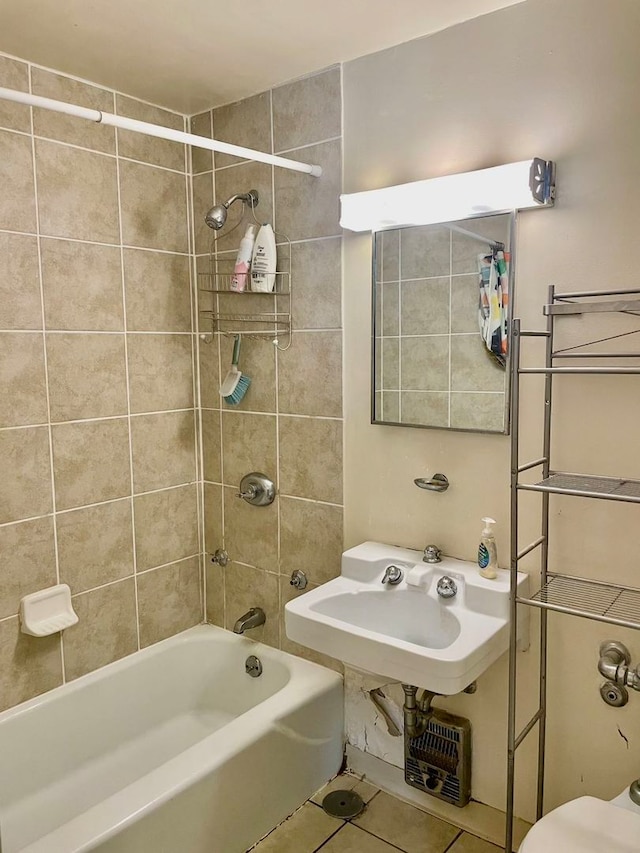 bathroom with tile patterned flooring, tiled shower / bath combo, and toilet