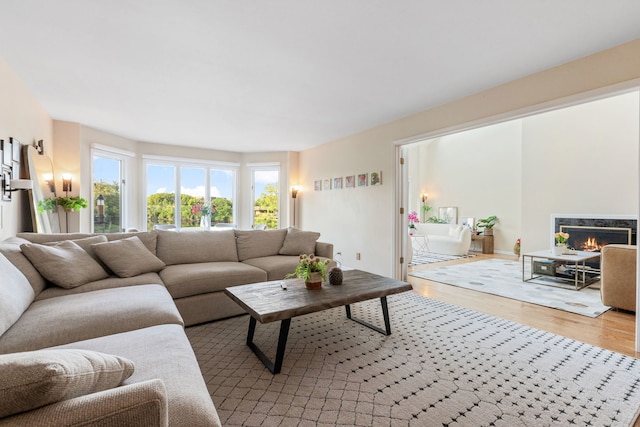 living room with light wood-type flooring and a high end fireplace