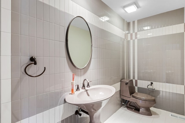 bathroom with tile walls, backsplash, and toilet