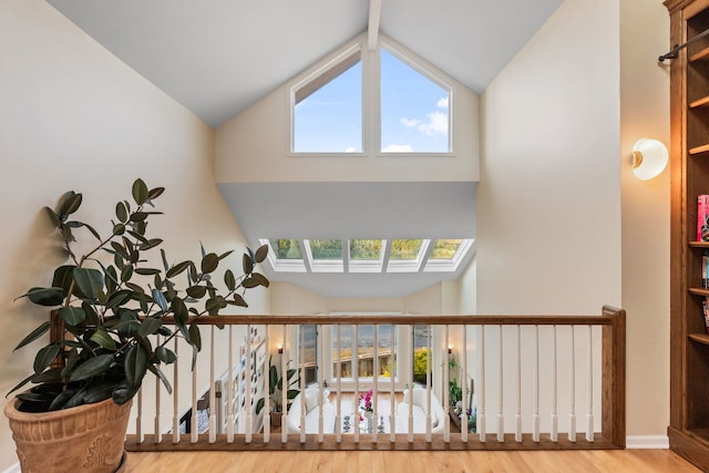 stairway with hardwood / wood-style floors and high vaulted ceiling