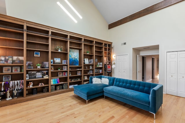 sitting room featuring wood-type flooring, beamed ceiling, and high vaulted ceiling