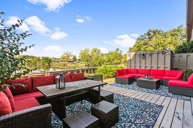 deck with a water view and outdoor lounge area