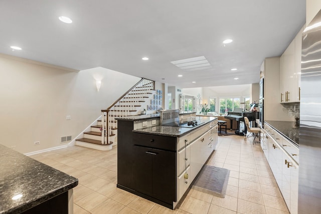 1204 Hawthorne Ln, Hinsdale, IL 60521 - kitchen with dark stone countertops, visible vents, stainless steel fridge, a kitchen island, and light tile patterned flooring