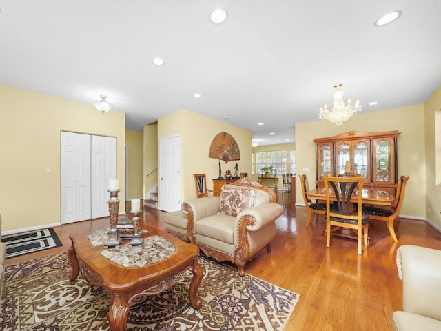 living room with a notable chandelier and light wood-type flooring