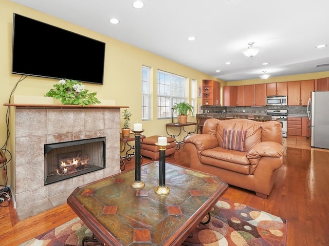 living room with light wood-type flooring and a fireplace