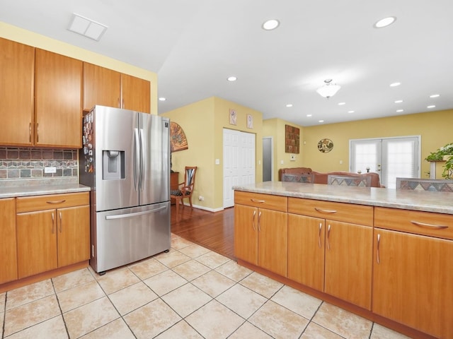 kitchen featuring light hardwood / wood-style floors, stainless steel fridge with ice dispenser, and decorative backsplash