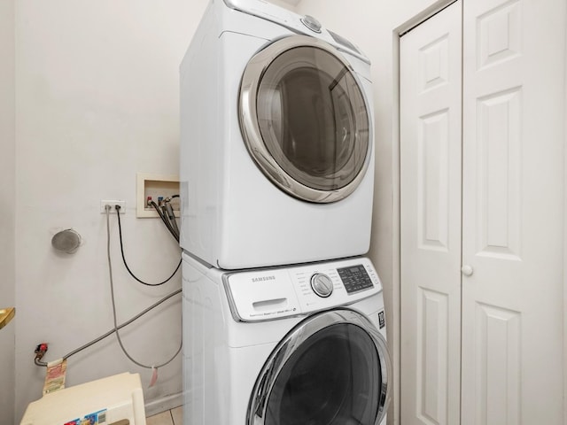 laundry area with stacked washer and dryer and tile patterned floors