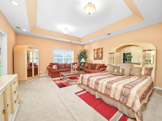 carpeted bedroom with a tray ceiling