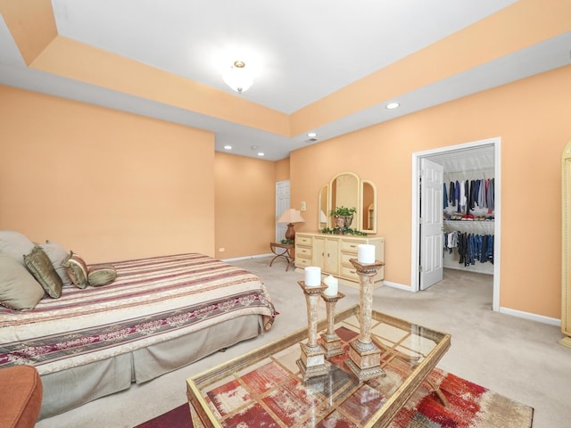 bedroom with carpet, a tray ceiling, and a closet