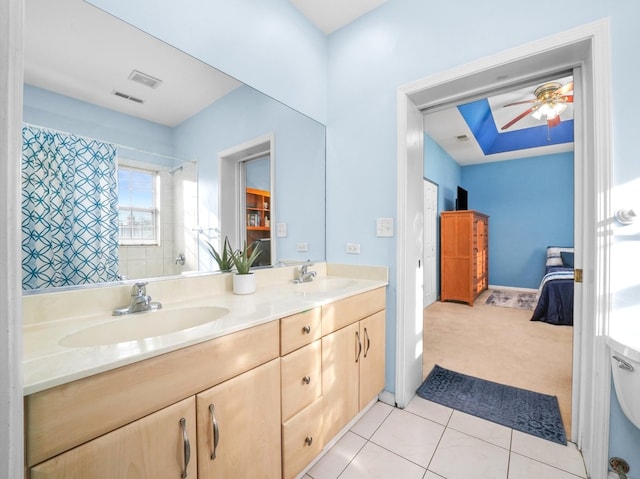 bathroom with curtained shower, vanity, ceiling fan, toilet, and tile patterned floors