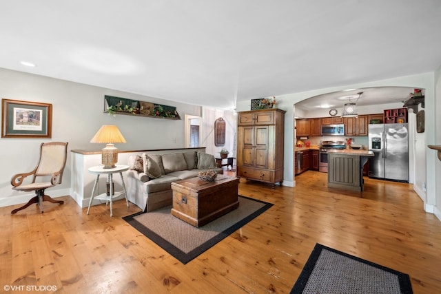 33 E Maple Ave, Cortland, IL 60112 - living area with arched walkways, light wood finished floors, and baseboards