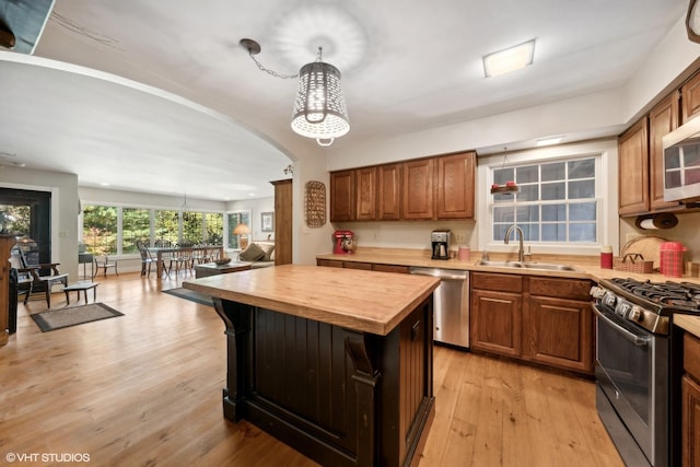 33 E Maple Ave, Cortland, IL 60112 - kitchen with stainless steel appliances, a sink, butcher block countertops, arched walkways, and a center island