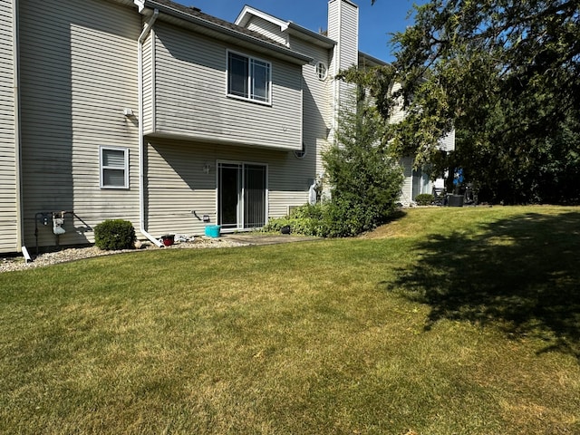 rear view of house featuring a yard