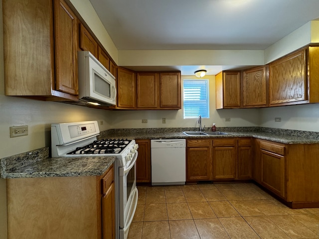 kitchen featuring white appliances, light tile patterned flooring, and sink