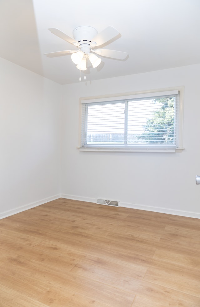 empty room featuring ceiling fan, light wood-type flooring, and plenty of natural light