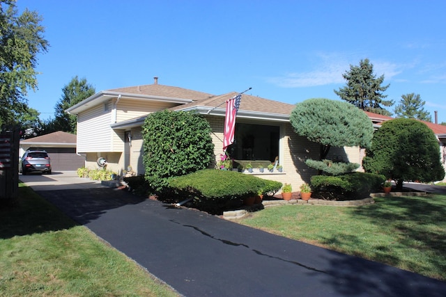 view of front of home with an outbuilding, a garage, and a front yard