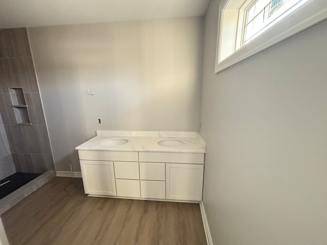 bathroom featuring hardwood / wood-style floors, vanity, and walk in shower