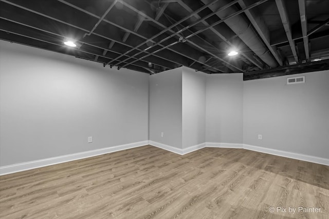 basement with hardwood / wood-style flooring