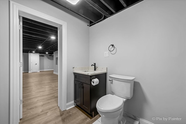 bathroom with vanity, toilet, and hardwood / wood-style flooring