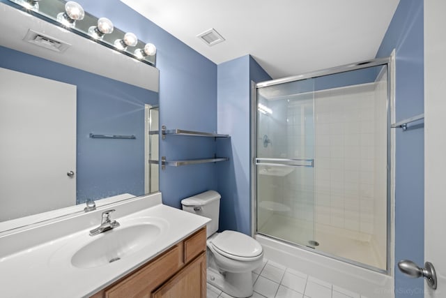 bathroom with tile patterned flooring, a shower with shower door, vanity, and toilet