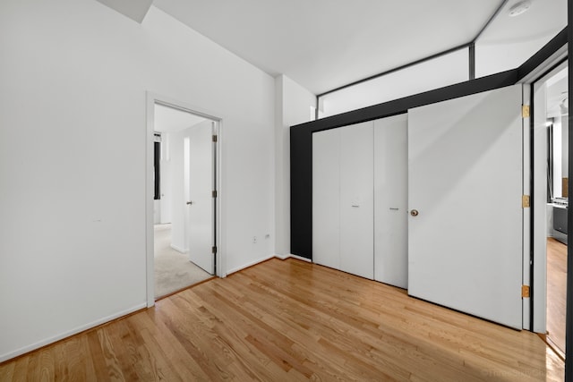 unfurnished bedroom featuring light hardwood / wood-style flooring and a closet