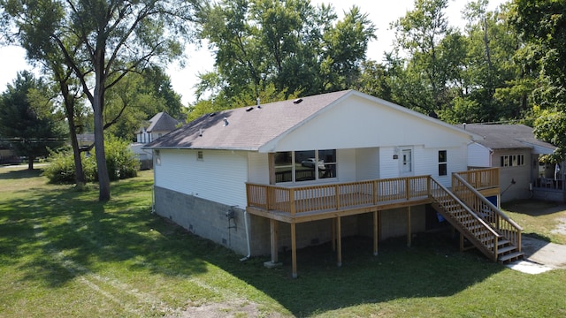 rear view of property with a deck and a yard