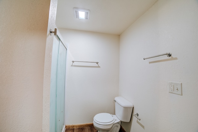 bathroom with hardwood / wood-style flooring and toilet