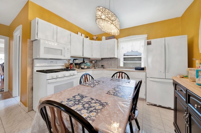 kitchen with a chandelier, white cabinetry, decorative backsplash, white appliances, and decorative light fixtures