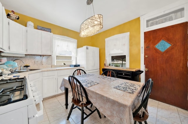 dining space featuring a notable chandelier and sink