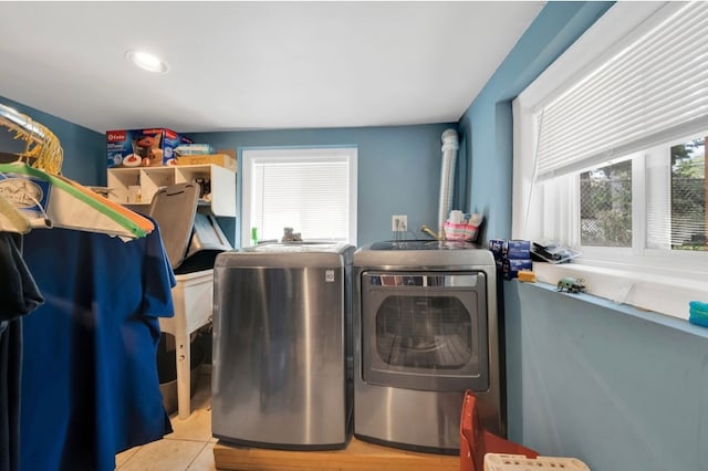 laundry area featuring light tile patterned flooring and washing machine and dryer