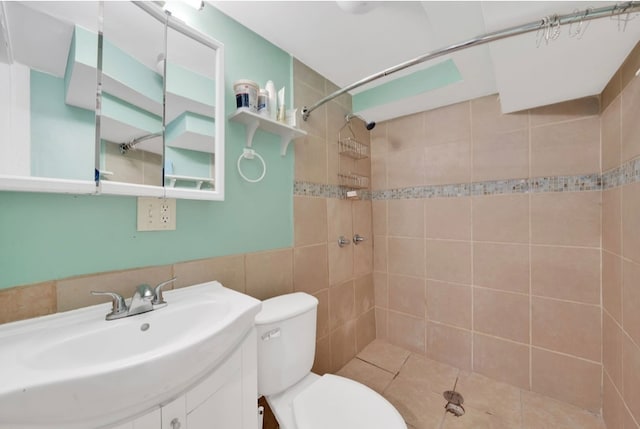 bathroom with vanity, tile patterned floors, toilet, and tiled shower