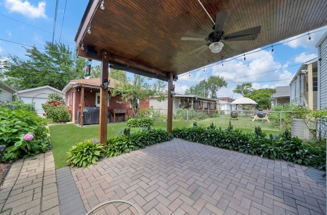 view of patio featuring ceiling fan, a grill, and an outbuilding