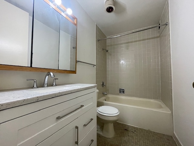 full bathroom with toilet, vanity, tile patterned flooring, and tiled shower / bath