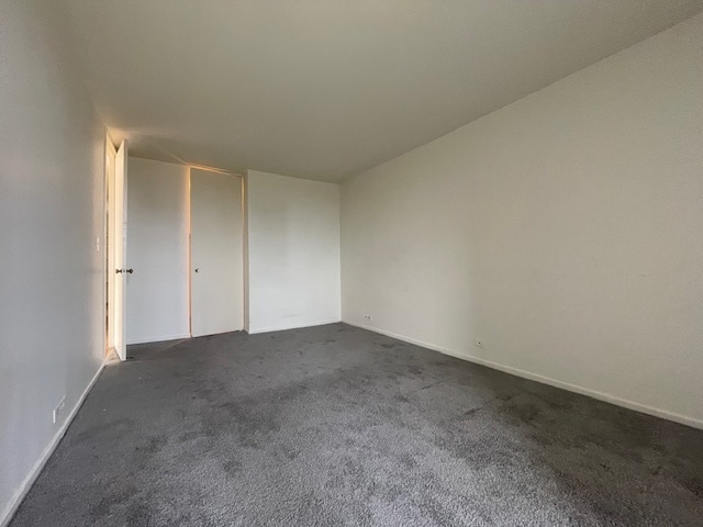 unfurnished bedroom featuring dark colored carpet