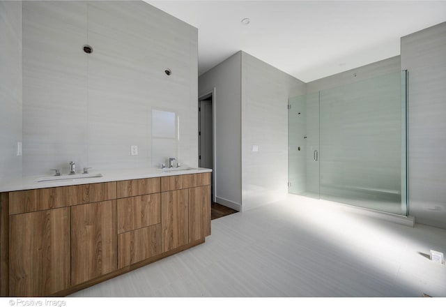 bathroom featuring walk in shower, tile walls, and vanity