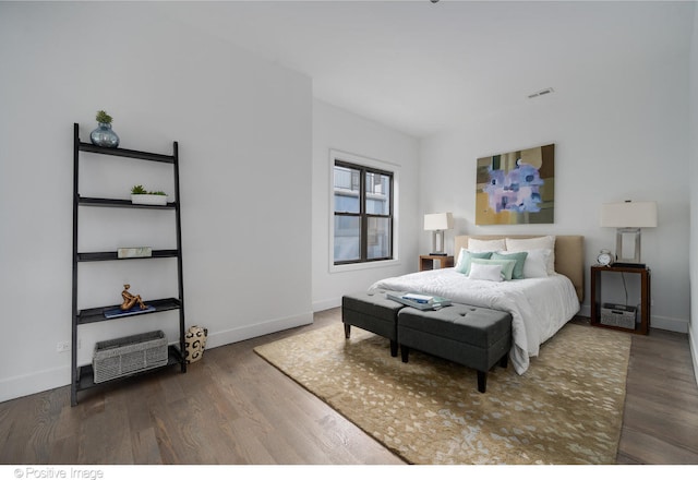 bedroom with dark hardwood / wood-style flooring