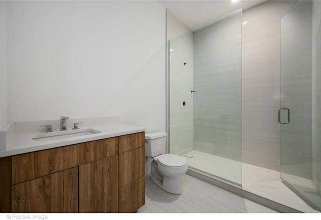 bathroom with a shower with shower door, vanity, and toilet