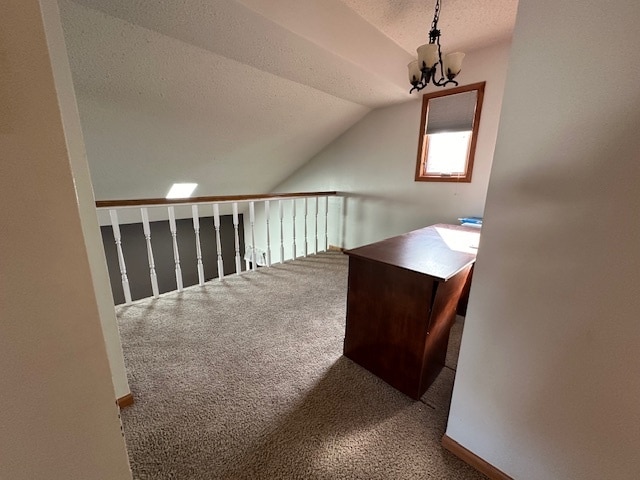 unfurnished office with a notable chandelier, lofted ceiling, carpet, and a textured ceiling