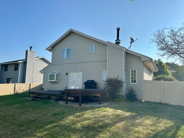 back of property featuring a lawn and a wooden deck