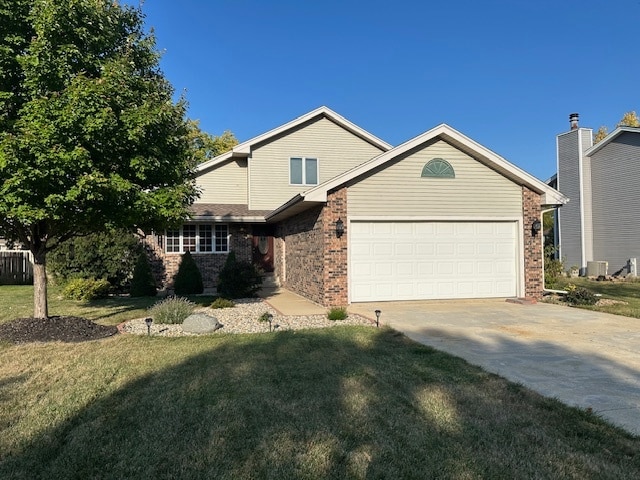 view of front of home with a garage, central AC unit, and a front yard