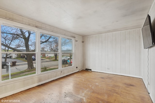 spare room with hardwood / wood-style flooring and wood walls