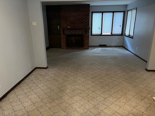 unfurnished living room featuring a brick fireplace and light colored carpet