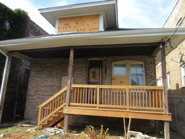 rear view of property featuring covered porch