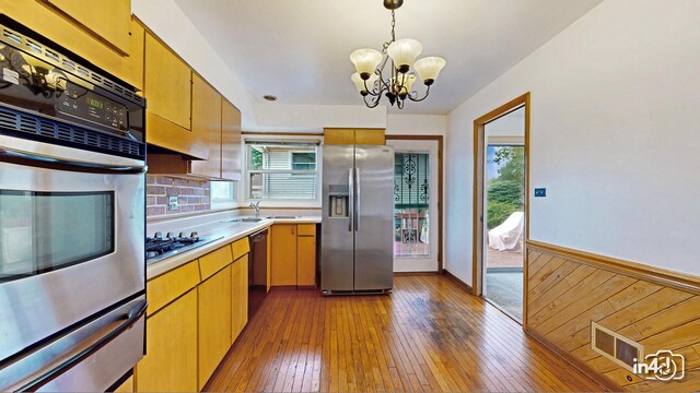 732 Luau Dr, Des Plaines, IL 60016 - kitchen featuring appliances with stainless steel finishes, a warming drawer, plenty of natural light, light countertops, and wainscoting