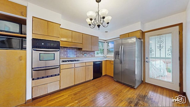 732 Luau Dr, Des Plaines, IL 60016 - kitchen featuring black appliances, a warming drawer, light wood-style floors, a chandelier, and light countertops