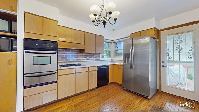 732 Luau Dr, Des Plaines, IL 60016 - kitchen featuring black appliances, a warming drawer, light wood-style floors, light countertops, and a chandelier