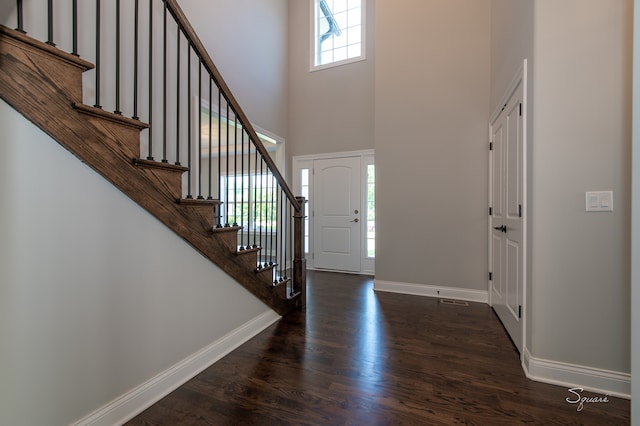 foyer with dark hardwood / wood-style flooring and a high ceiling