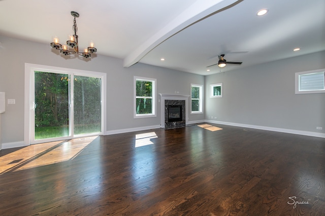 unfurnished living room featuring ceiling fan with notable chandelier, dark hardwood / wood-style floors, beam ceiling, and a high end fireplace