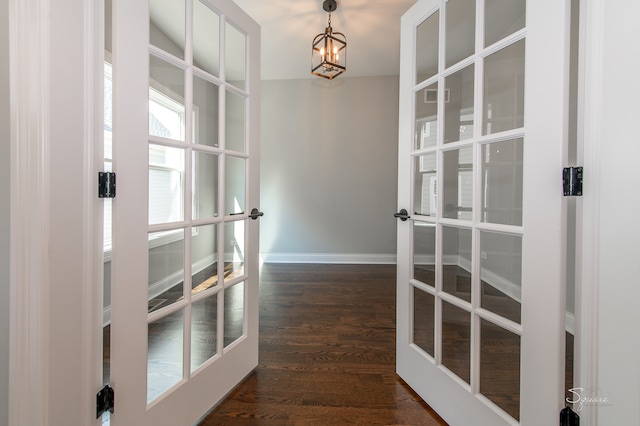 interior space with an inviting chandelier, french doors, and dark hardwood / wood-style flooring